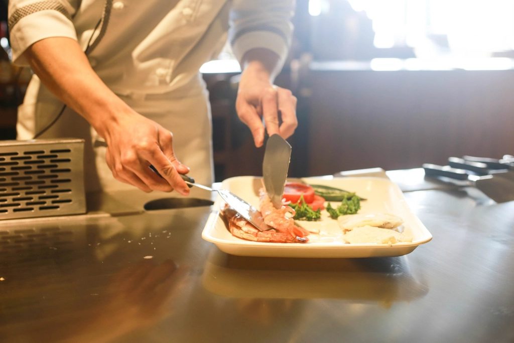 A chef plating a shrimp dish